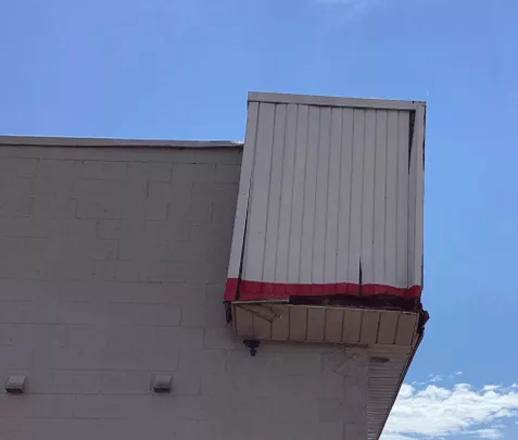 damaged siding and soffit on building after storm