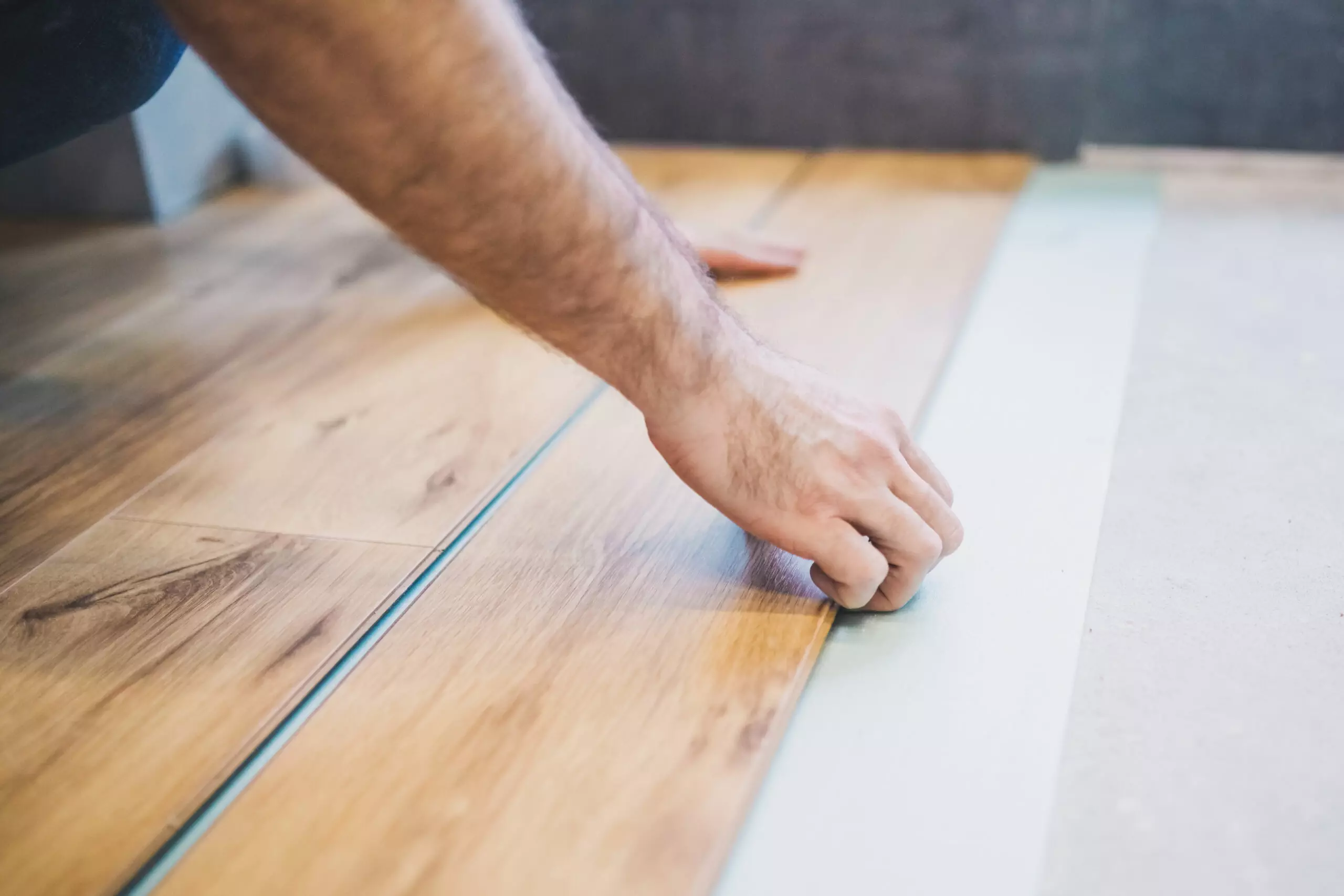 The builder is engaged in laying laminate in the room - repair and finishing work
