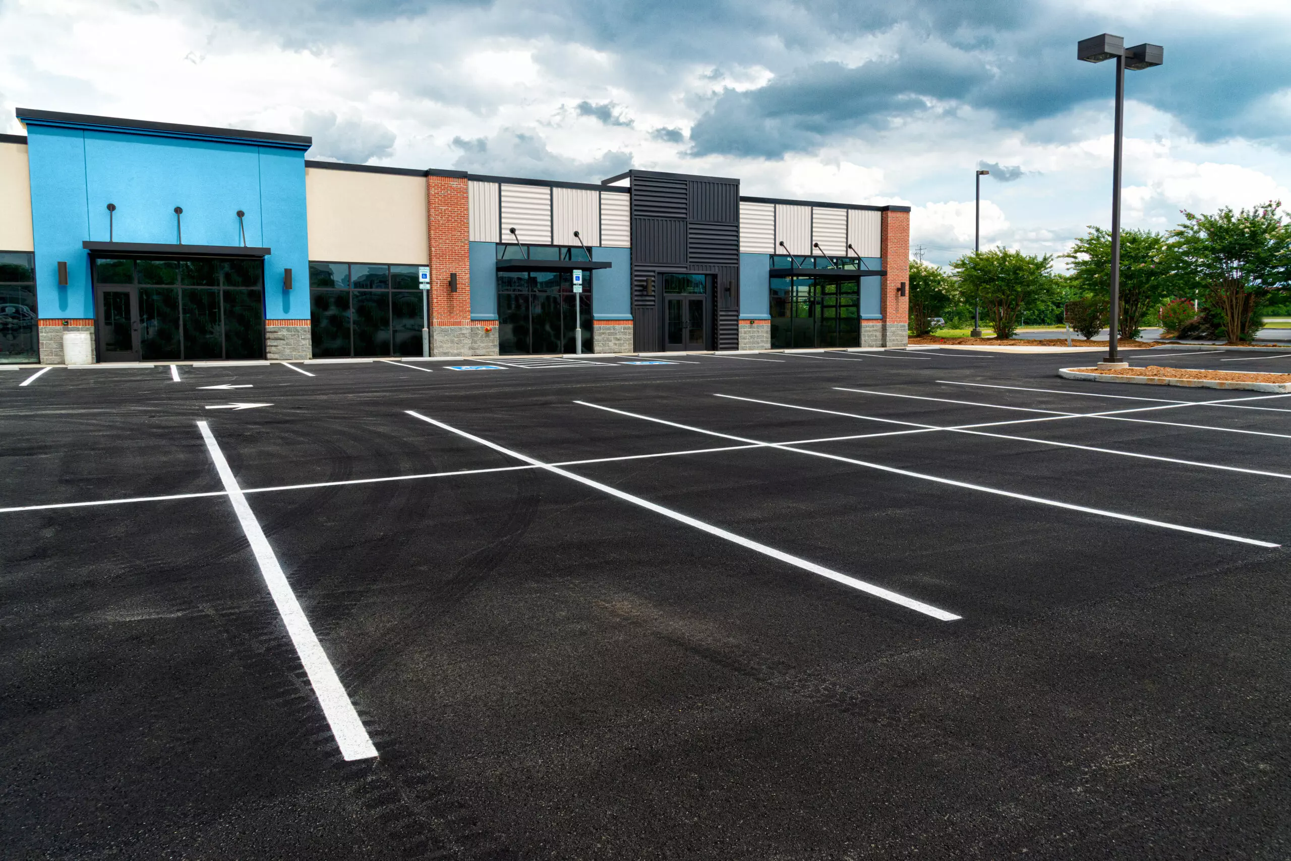 Horizontal shot of a new strip shopping center with no customers and an empty parking lot.